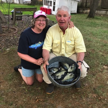 A couple showing off a pan of fish they caught on Lake Prairie.